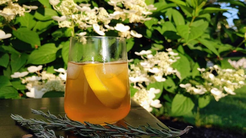Un verre de thé glacé au citron et au romarin.