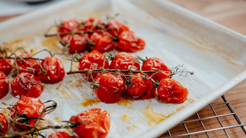 Des grappes de tomates cerises rôties sur une plaque à pâtisserie.