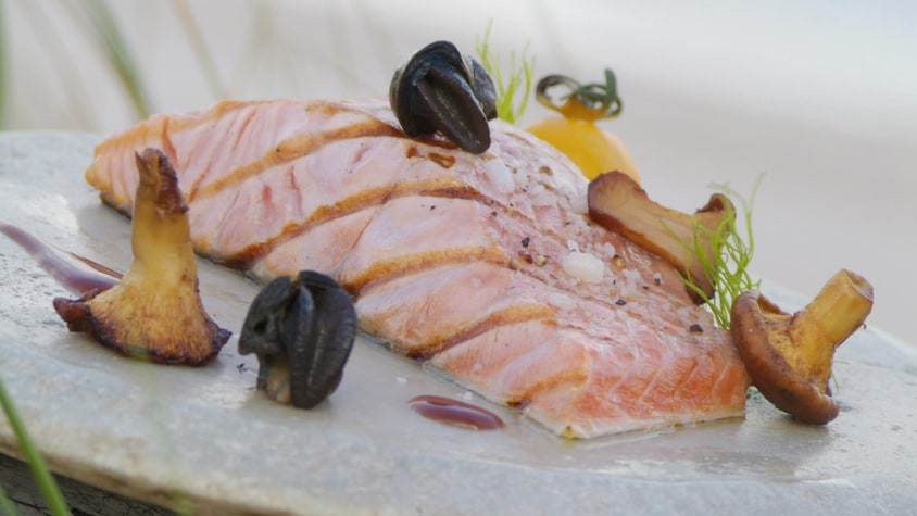 Des tranches de saumon de l'Atlantique grillées, sauce au vin rouge sur un plat.