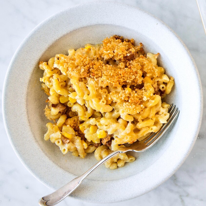 Une assiette de macaroni et le plat sortant du four à côté.