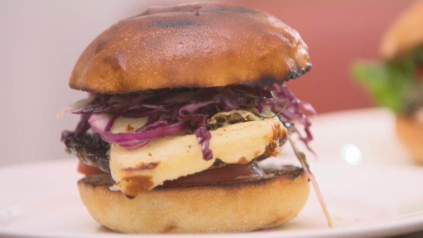 Un burger au champignon et au fromage avec salade de chou dans une assiette.