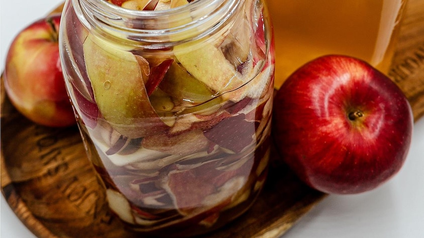 Un pot Mason remplit de pelures de pommes.