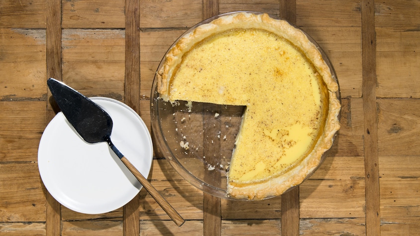 Une tarte, dont il manque un morceau, est sur la table.