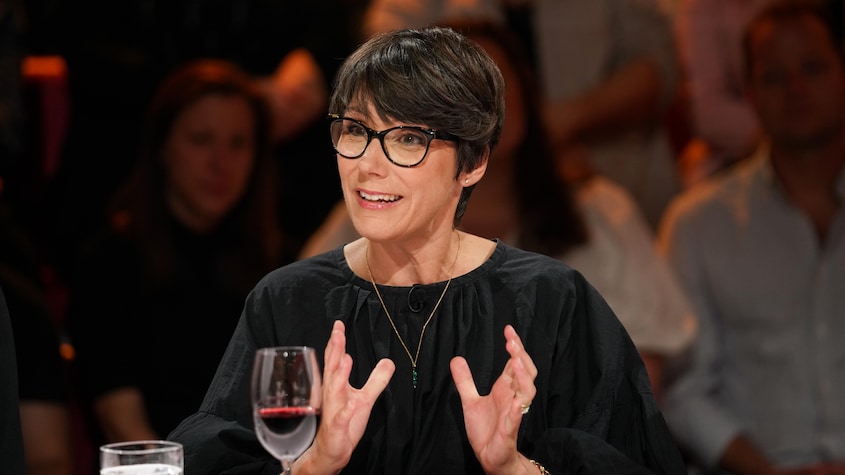 A Média Une femme à la table des invités.