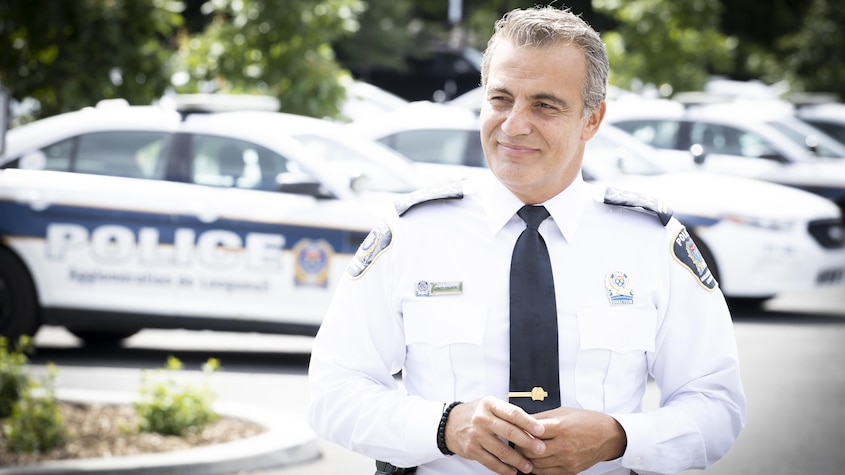 Radio-Canada Un policier devant des voitures de police.