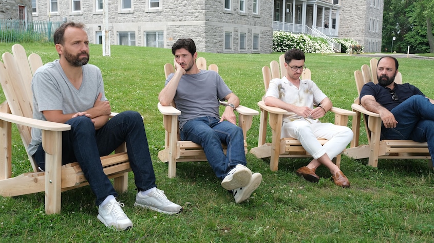François, Marc-André, Vincent et Patrick assis dehors devant un établissement de santé.