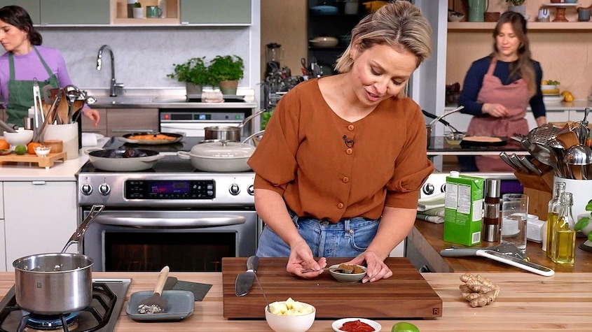 Dans la cuisine de l'émission, Isabelle Deschamps-Plante tient une cuillère remplie d'épice.