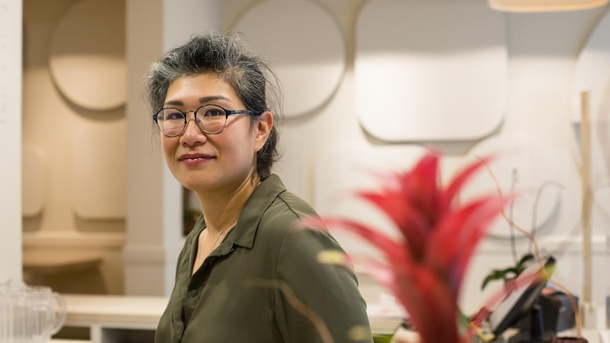 Minh Hieu Phan pose derrière le comptoir de son restaurant.
