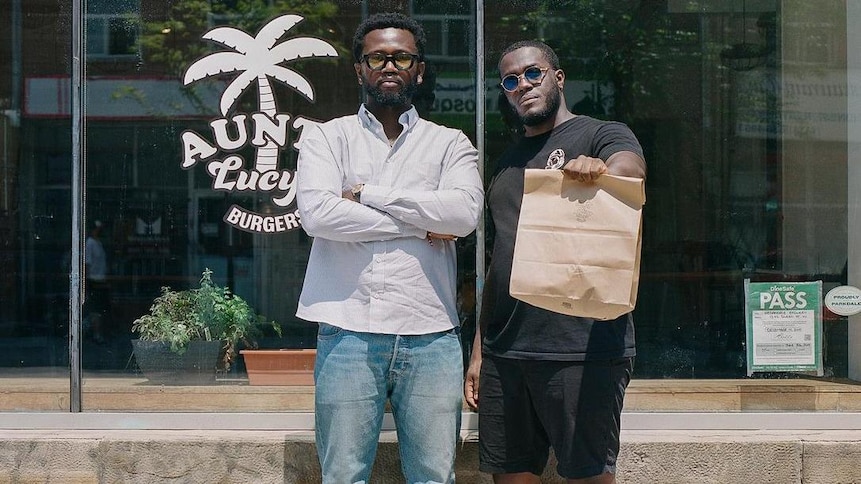 Chieff Bosompra et Adrian Forte se tiennent devant le restaurant Aunty Lucy's. 