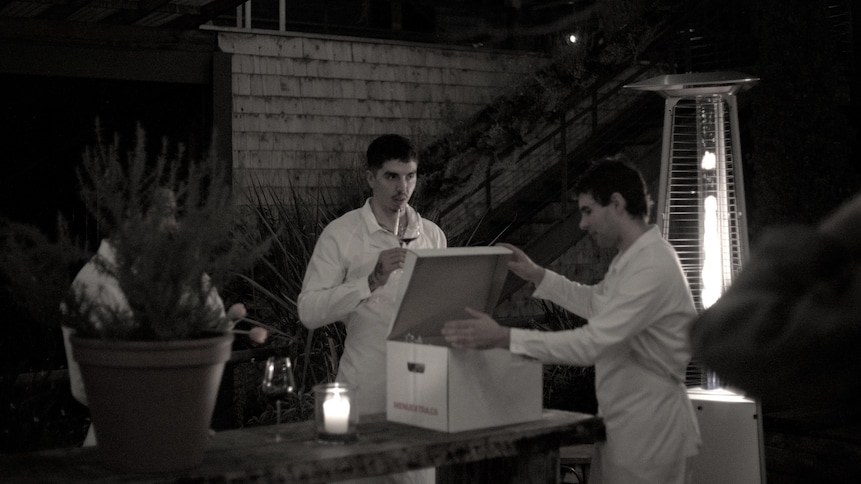 Camilo et Francis ouvrent une de leurs boîtes contenant les repas à emporter.