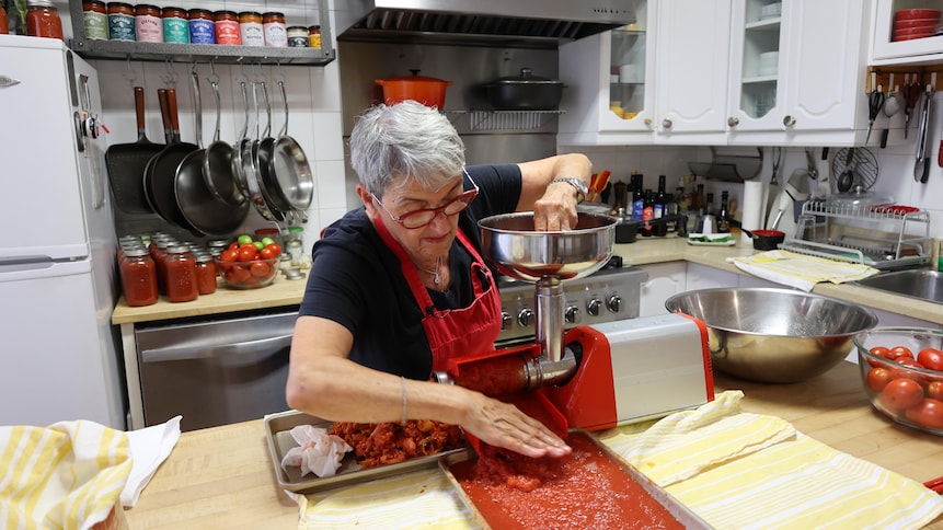 Elena Faita opère un moulin à tomates dans sa cuisine.