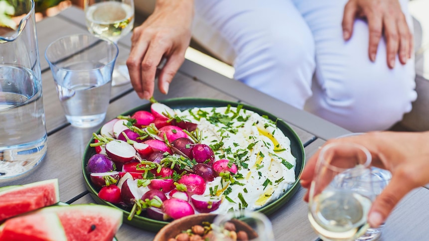 Assiette de ricotta fouettée avec des radis et du persil.