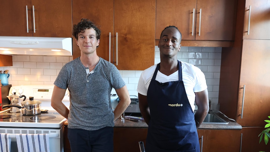 Jerémie Jean-Baptiste et son invité dans une cuisine devant une casserole de risotto au fenouil.