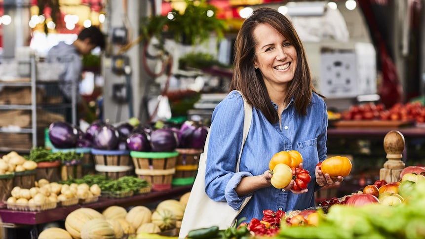 La nutritionniste Geneviève O'Gleman se trouve au marché avec des tomates dans les mains.