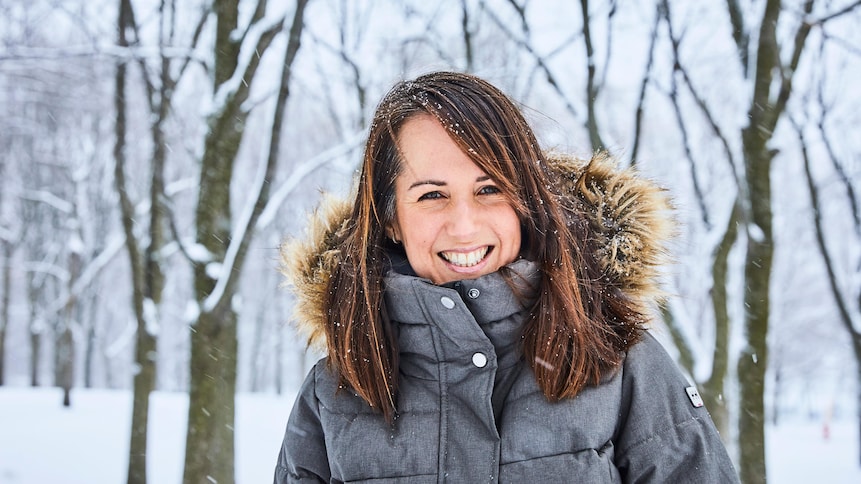 La nutritionniste Geneviève O'Gleman est dehors dans une forêt enneigée et porte un manteau d'hiver gris. 