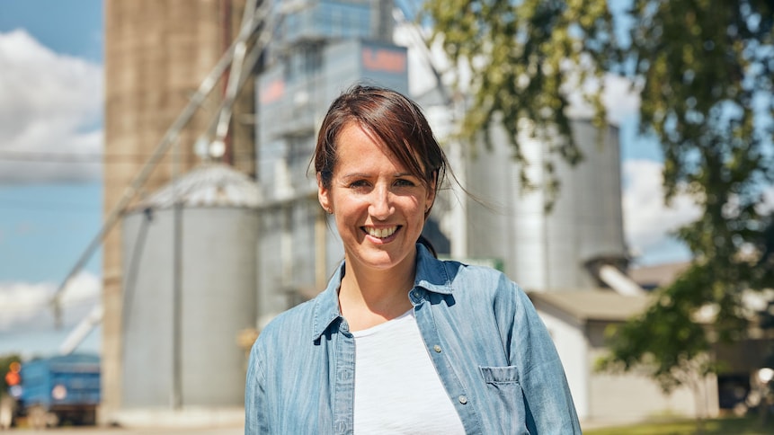 Geneviève O'Gleman pose devant une usine de grains située en Montérégie.