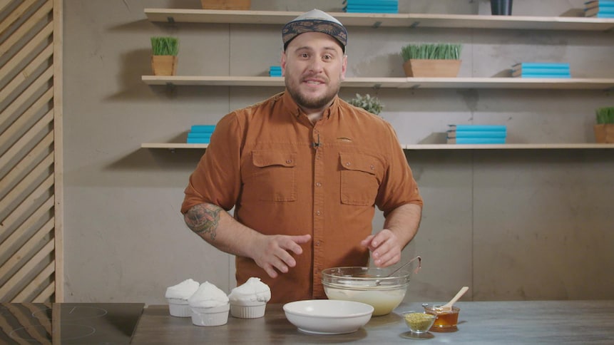 Rémy Couture dans une cuisine avec plusieurs ingrédients devant lui.