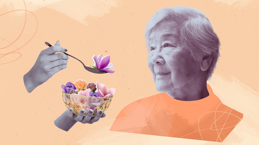 Un préposé aux bénéficiaires nourrit une vieille dame avec des fleurs.