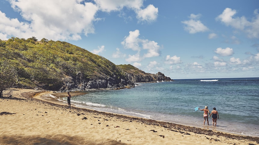 Une plage de Martinique avec quelques baigneurs.