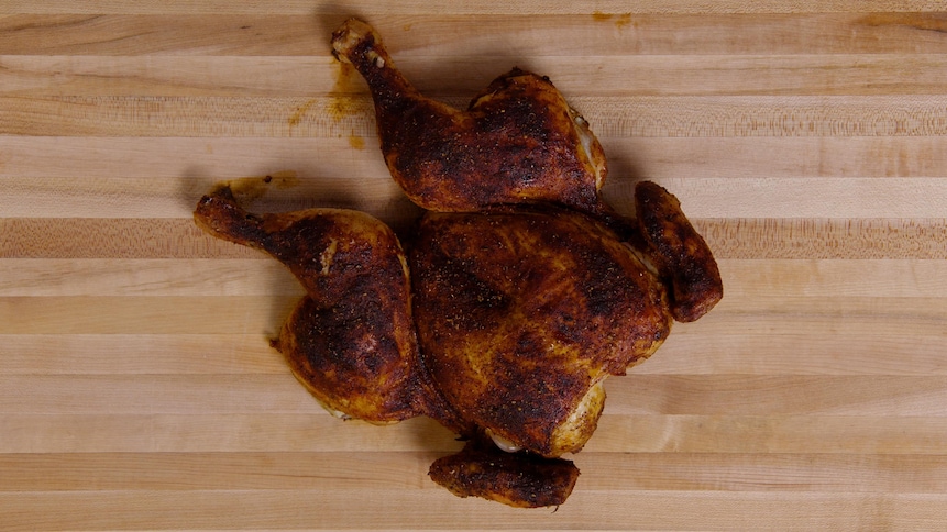 Un poulet en crapaudine sur un comptoir.