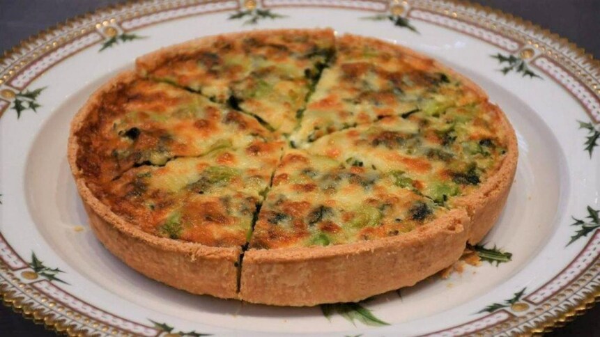 Une quiche aux épinards, aux gourganes et à l'estragon dans une assiette.