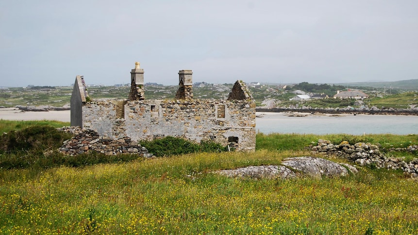 Vieux bâtiment irlandais de pierre en ruine près d'un plan d'eau.