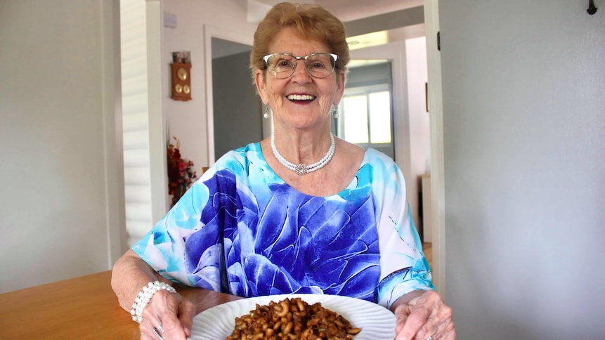 Une femme avec une assiette de macaroni chinois devant elle.