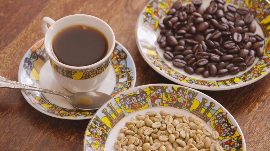 Une tasse de café, et des grains de café dans des assiettes.