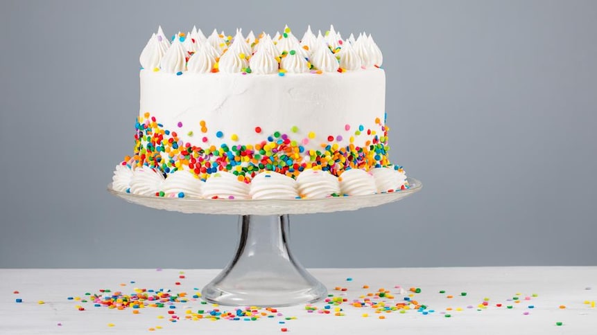 Un gâteau avec du glaçage blanc et des décorations multicolores.