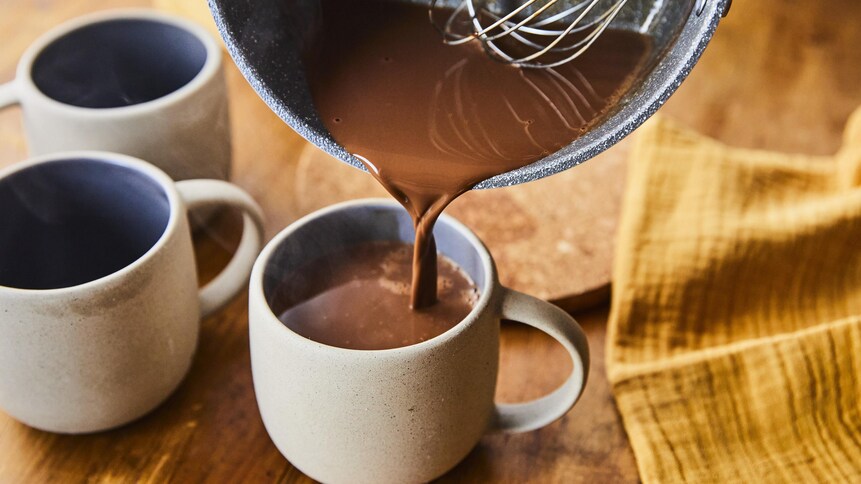 On verse le chocolat chaud dans une tasse.