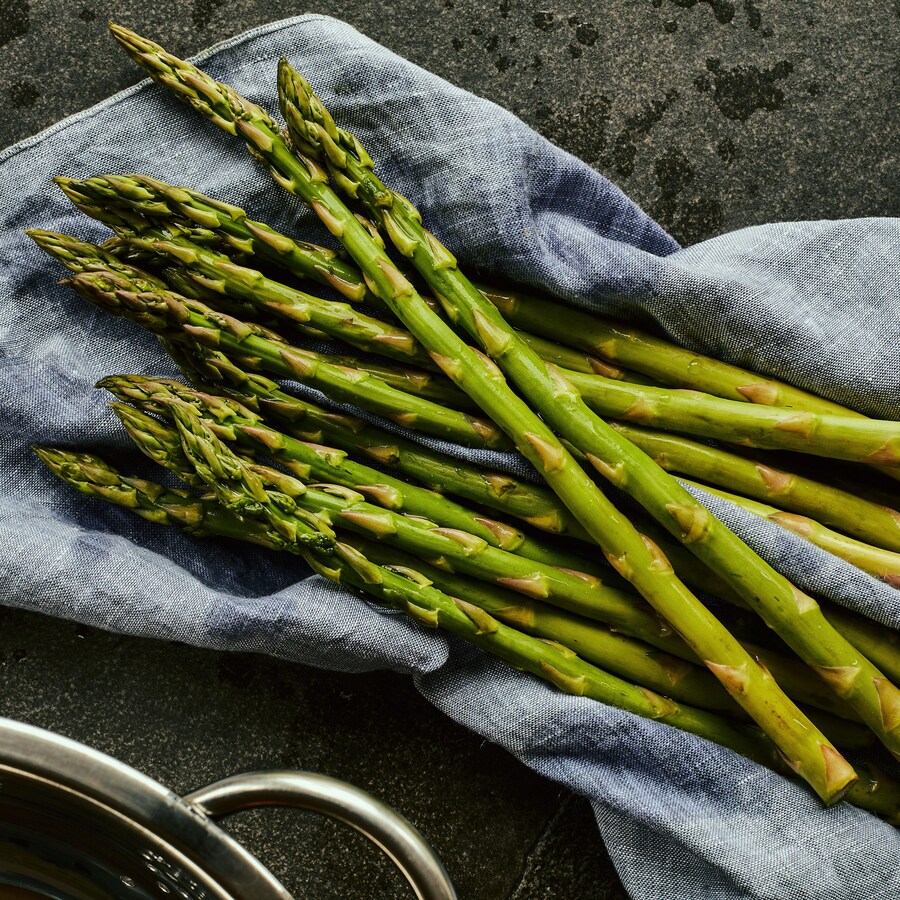 Asperges crues déposées sur un linge bleu jeans.