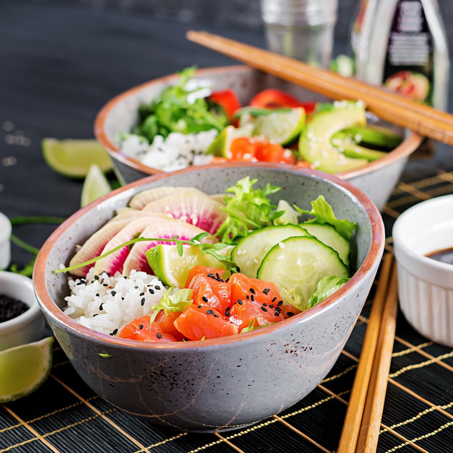 Deux bols sushi garni de poisson cru, de riz et de légumes.