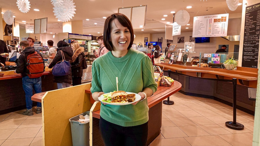 La nutritionniste Geneviève O’Gleman tient une assiette de nourriture et se tient devant la cafétéria de l’école Polytechnique de Montréal.