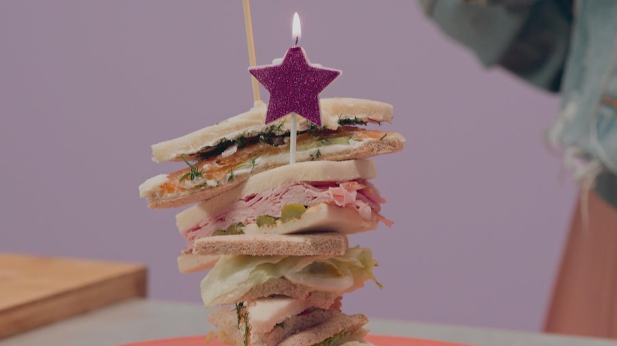 Une bougie en forme d'étoile trône sur une montage de sandwichs pas de croûtes. 