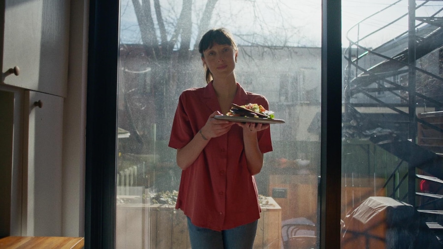 Sarah-Maude Beauchamp tient dans ses mains une assiette de salade à la samo.