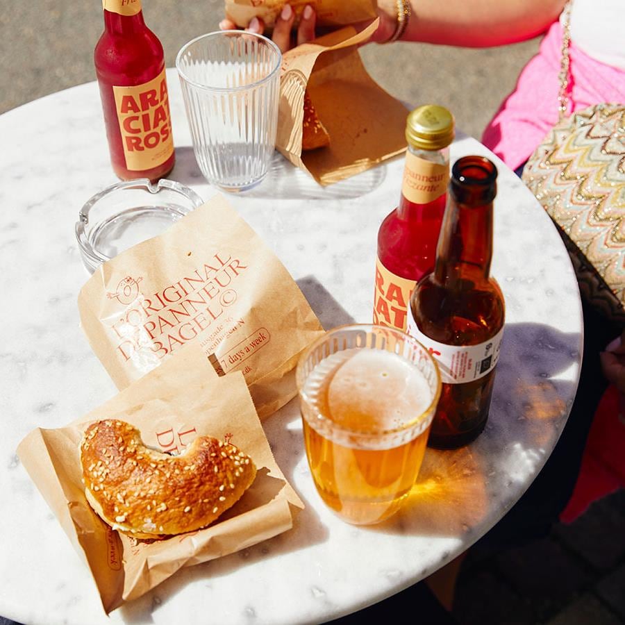 Des bagels et de la bière sur une table ensoleillée.
