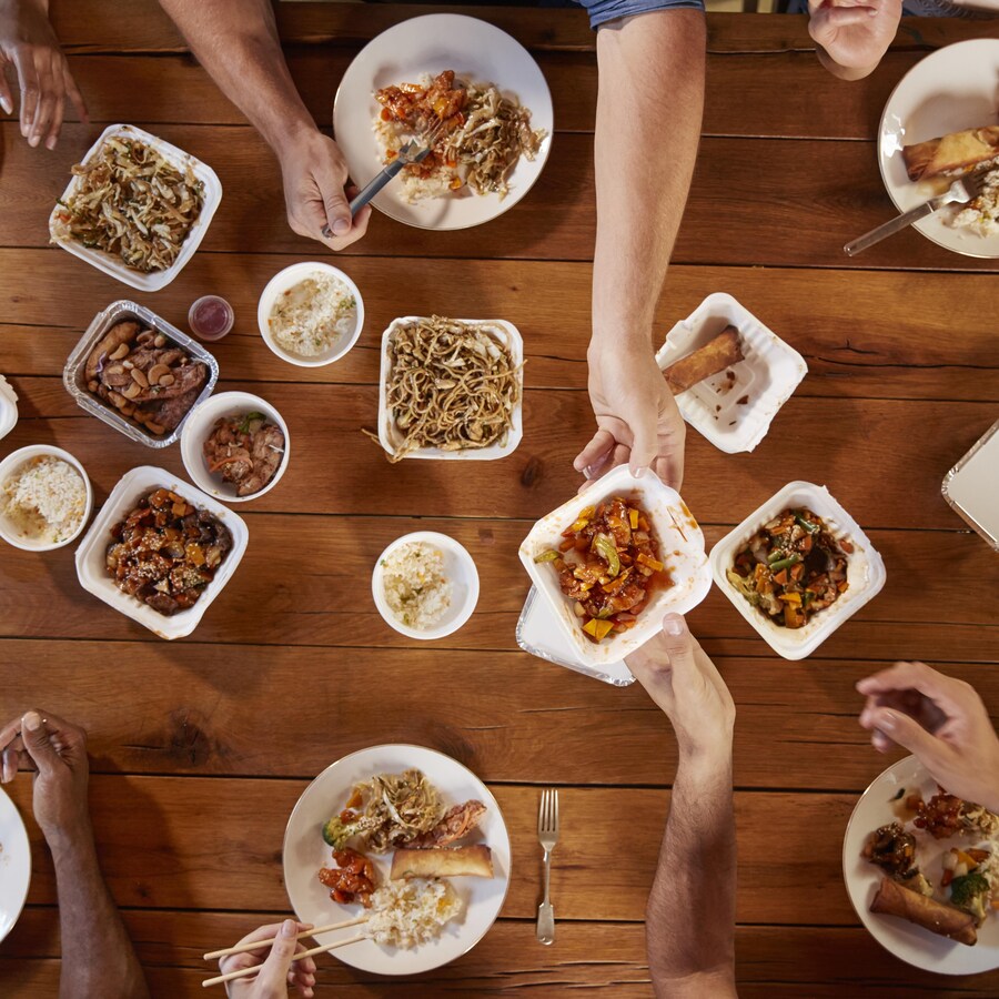 Des gens à une table qui se partagent des plats.