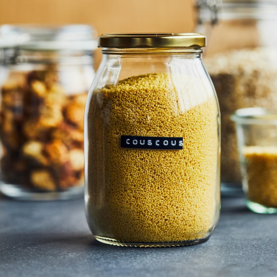 Pot de verre avec un couvercle de métal contenant du couscous.