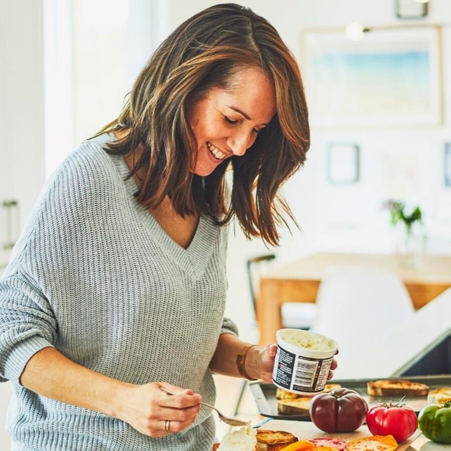 Geneviève O'Gleman tartine une toast de fromage crémeux. 