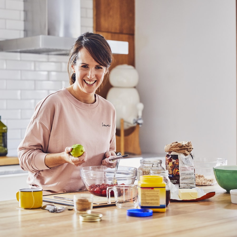 Geneviève O'Gleman dans sa cuisine en train de zester une lime.