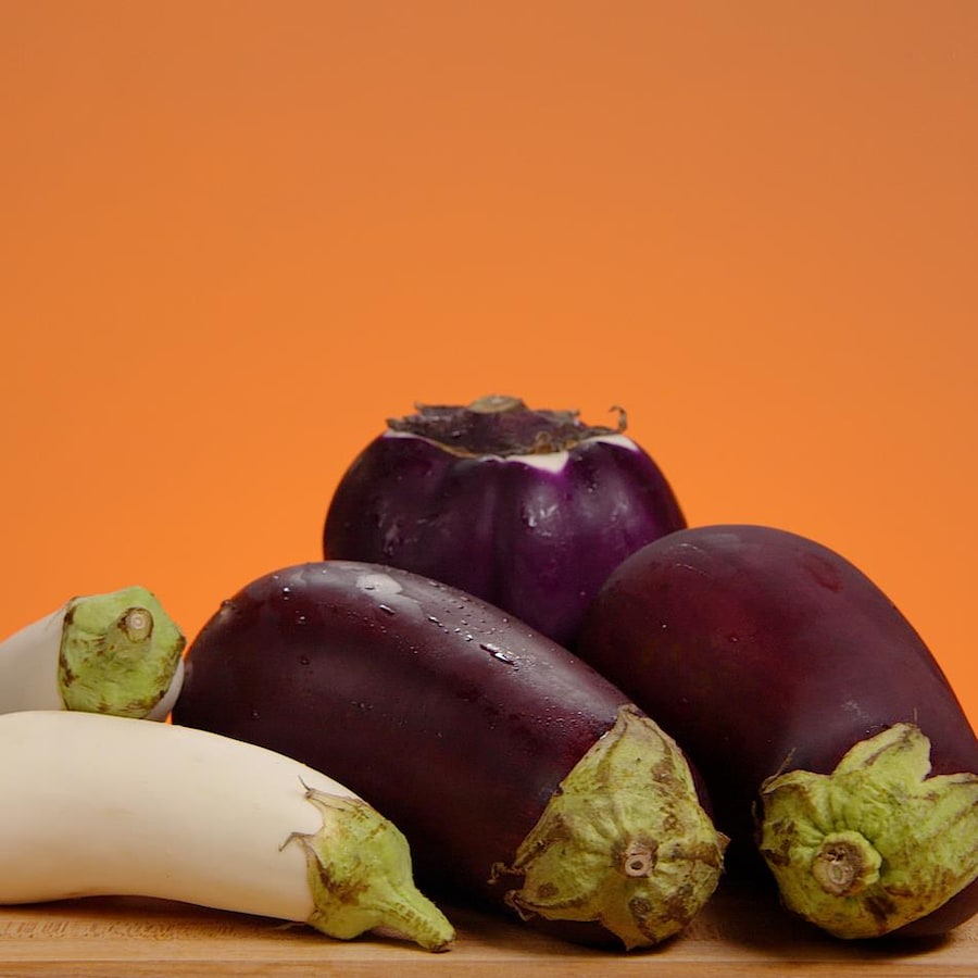 Différentes variétés d'aubergine sur une planche à découper.