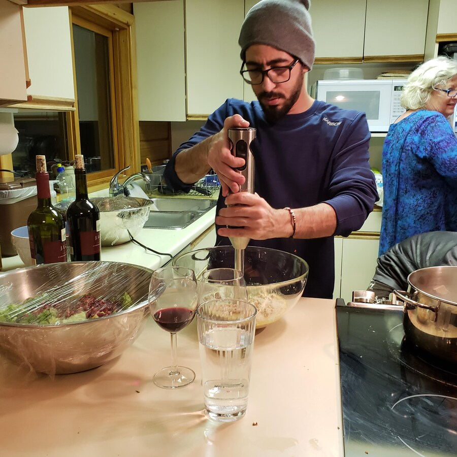 Hassan en train de préparer un repas dans la cuisine de la maison où il vit désormais, au Canada.