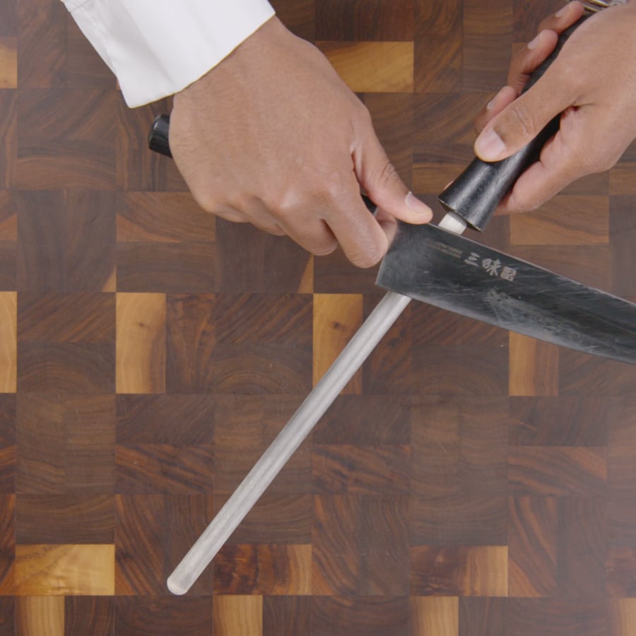 Une personne utilise un tige de métal ou de céramique permet de ramener la lame du couteau