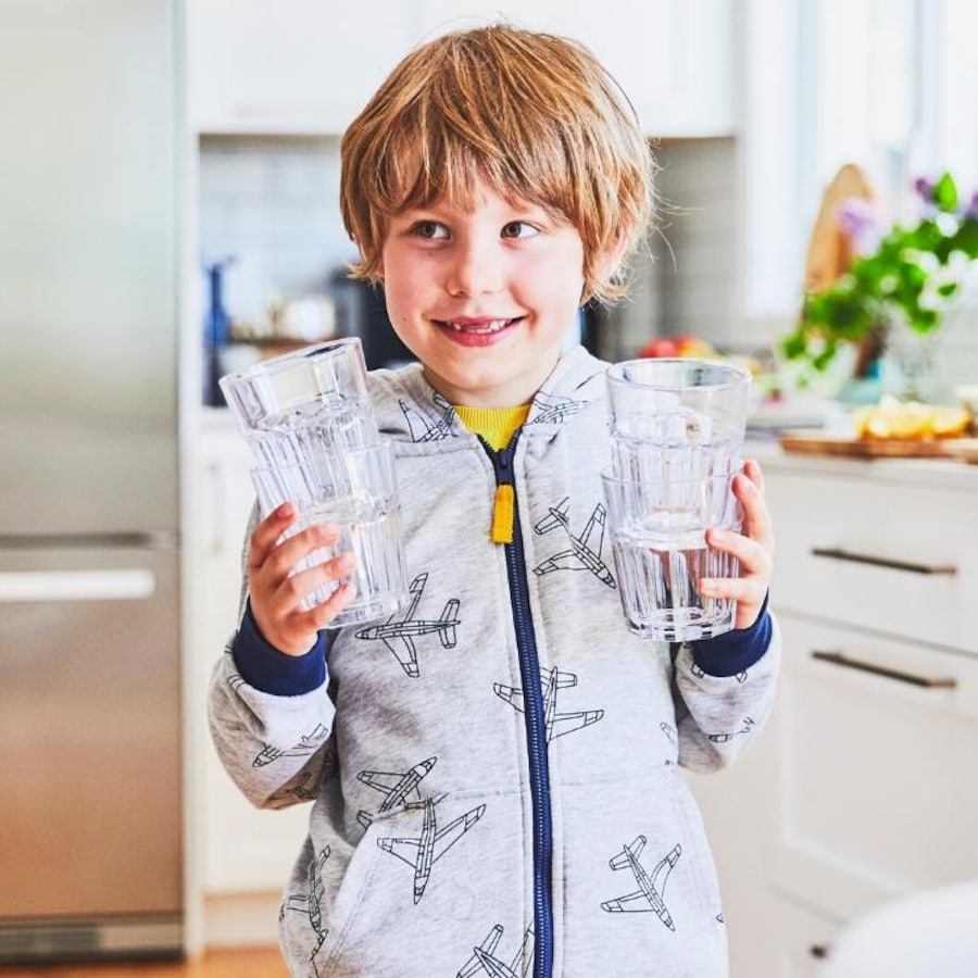 Garçon qui tient des verres vides dans ses mains.