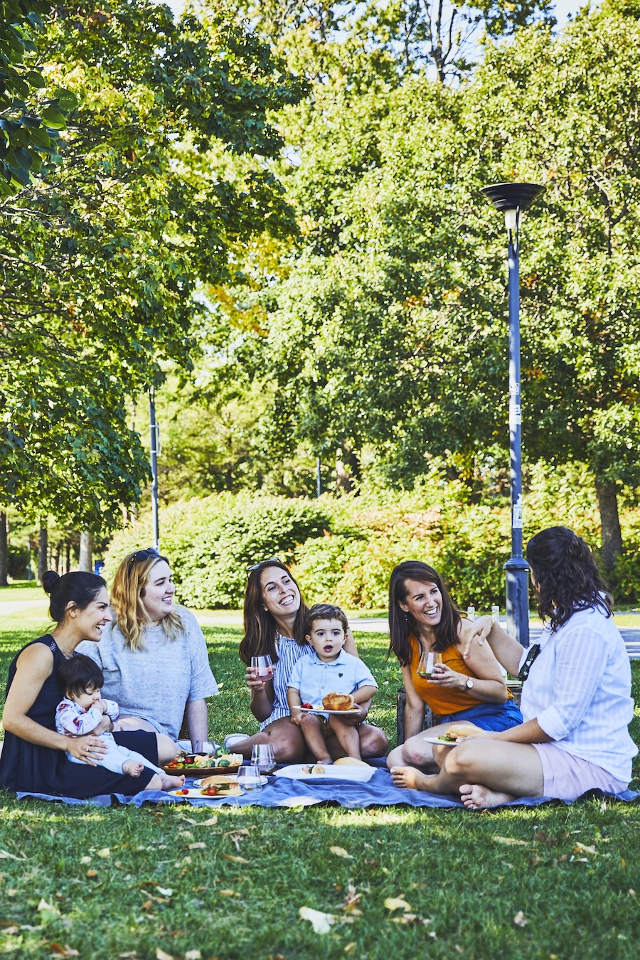 Un groupe d’amis font un pique-nique dans un parc. 