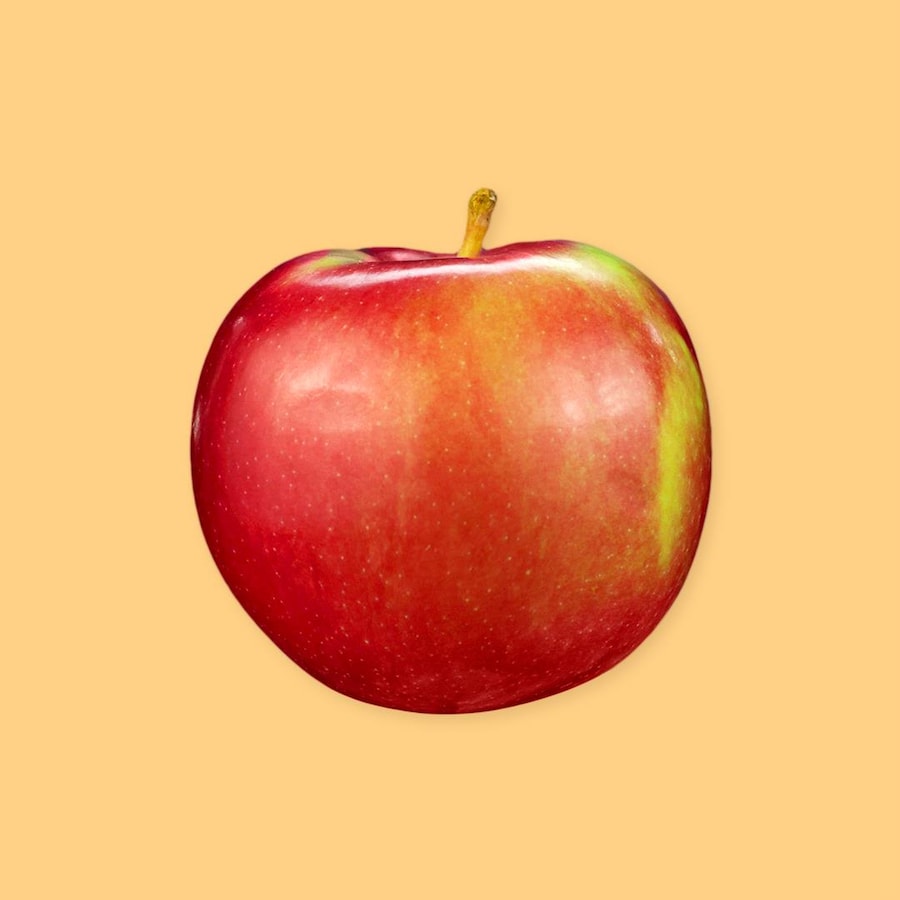 Une pomme sur un fond jaune.
