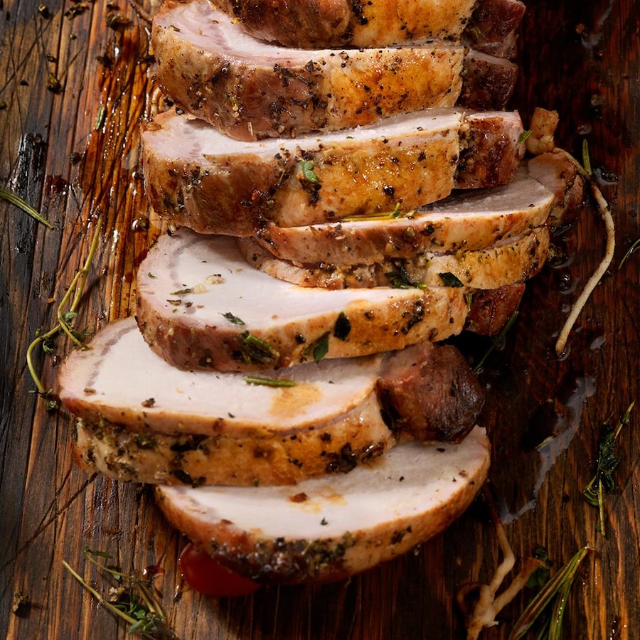 Des tranches de porc coupées sur une planche de bois.
