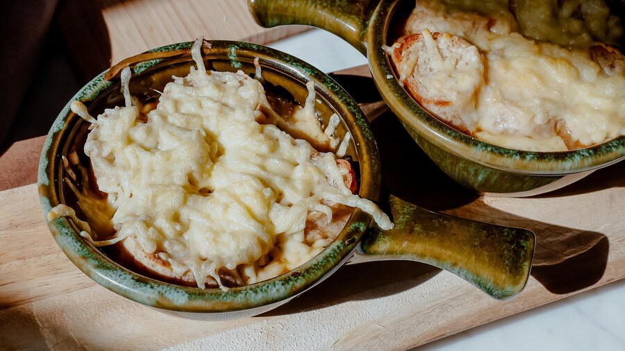 Deux bols de soupe à l'oignon gratinée avec une couche généreuse de fromage.