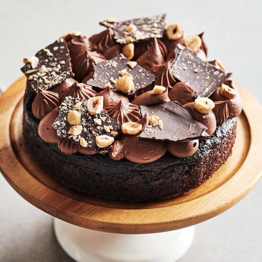 Un petit gâteau au chocolat sur un présentoir à gâteau.