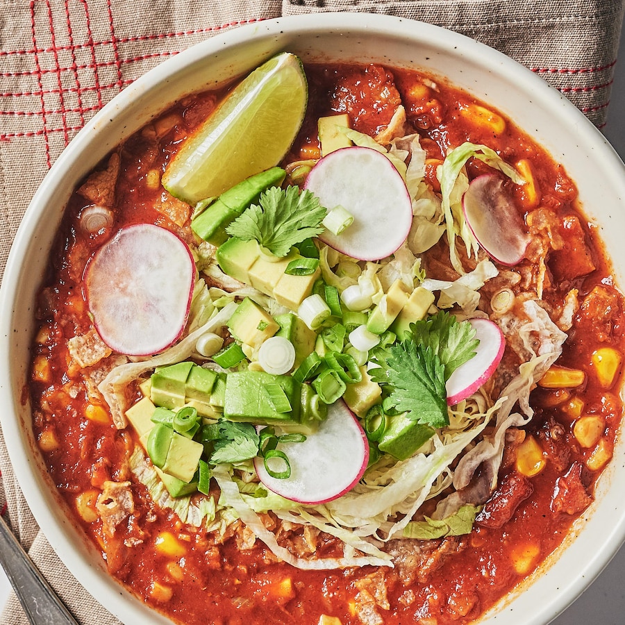 Un bol de soupe pozole mexicaine, garnie de légumes et de lime.